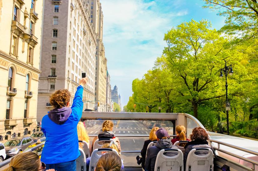 游客在春季开放式屋顶巴士欣赏纽约市的景色；蓝色的女人正在用智能手机拍照。Shutterstock ID 1399814936;您：Zach Laks；GL：65050;NetSuite：在线社论；完整：发现